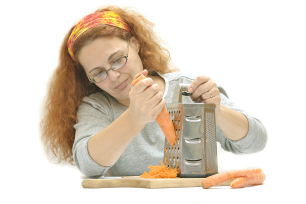 女人在切菜板上刨胡萝卜图片下载