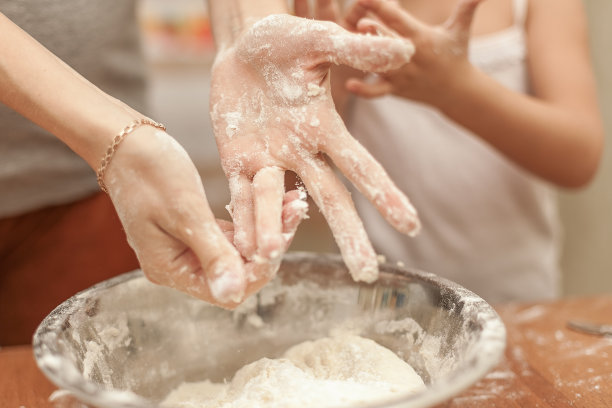 一个女人和一个小女孩在一个碗里揉面。清洗手图片下载