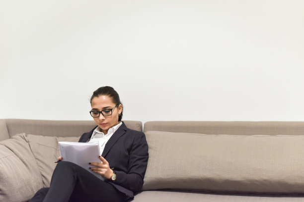 年轻的女商人在沙发上工作图片下载