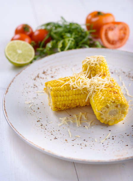 白盘子上的烤玉米和黄油图片下载