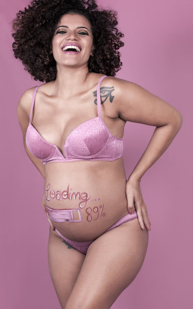 美丽又快乐的孕妇画着肚子图片下载