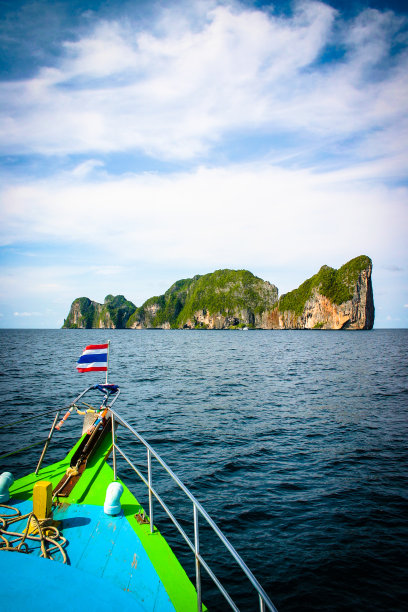 海洋里巨大的岩石。拥有绿色森林和棕榈树的小岛。蓝天和白云。在科phi phi附近的一次乘船旅行中。图片下载