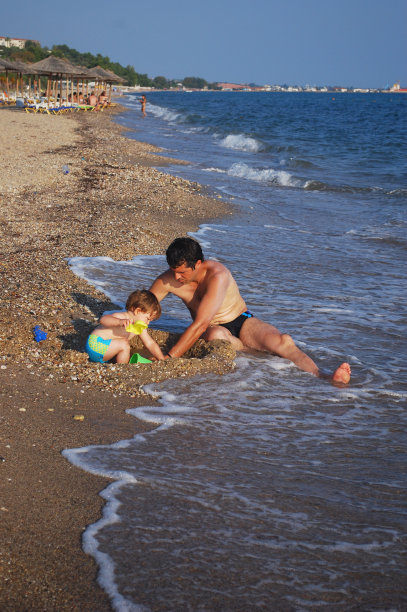 爸爸和儿子在海滩上玩图片下载