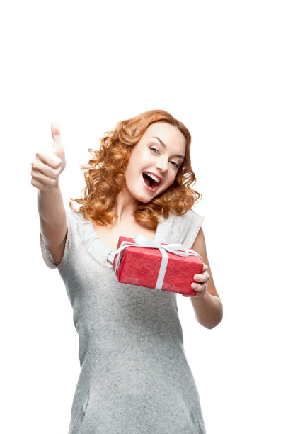 年轻的红头发的随意女孩与红色的礼物显示大拇指图片下载