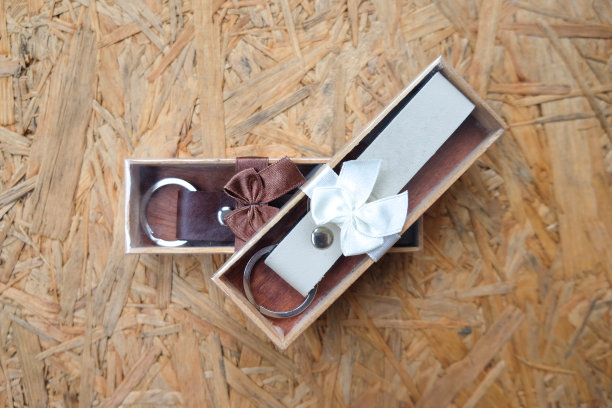 婚礼礼物给客人，钥匙圈皮革在木箱上的木材背景图片下载
