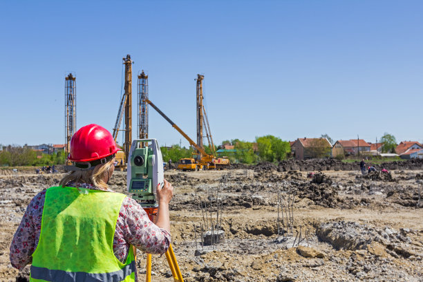 女性测地线师在建筑工地与全站仪一起工作图片下载