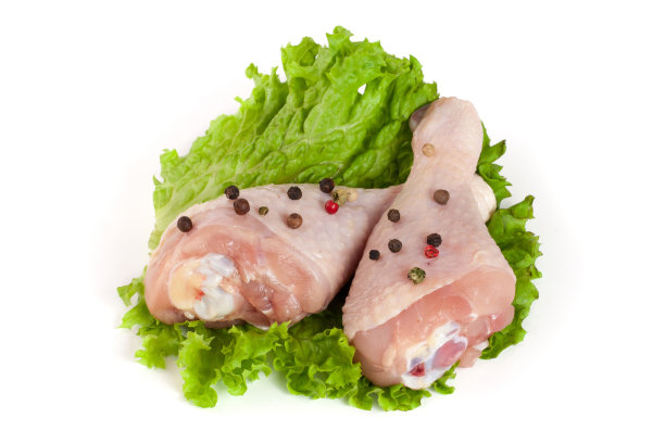 两个生鸡腿与生菜叶孤立在白色背景图片下载