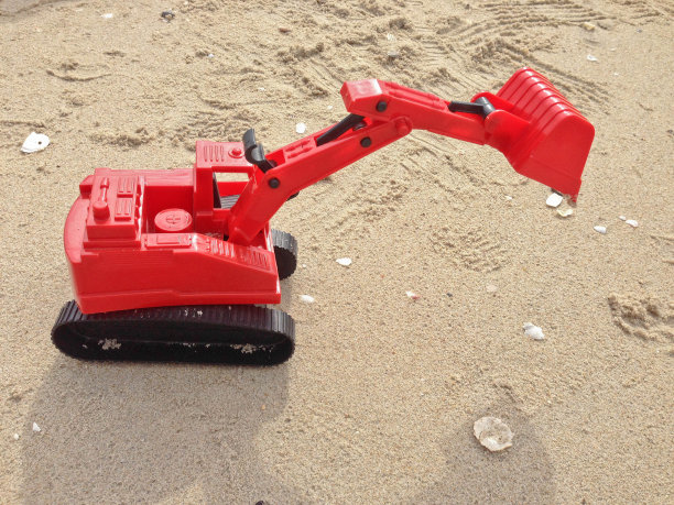 儿童玩具沙上的红色挖掘机车，工业标志图片下载