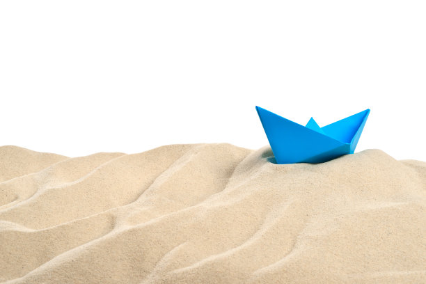 在海滩上-沙丘与蓝色纸船在前面的白色背景-剪切路径包括图片下载