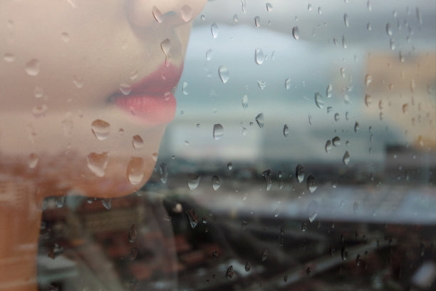 雨中窗边的女士。图片下载