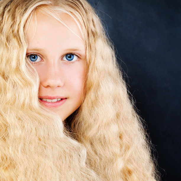 漂亮的孩子女孩在蓝色的背景。金色长发，脸部特写图片下载