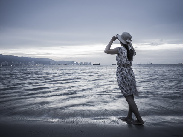 坚强自信的女人在海边的日出下张开双臂图片下载