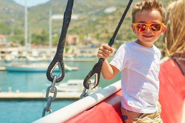 有趣的小男孩摆姿势在游览船附近美丽的山脉图片下载