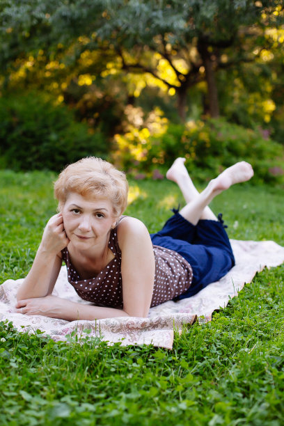 一位中年妇女在公园里微笑的肖像图片下载