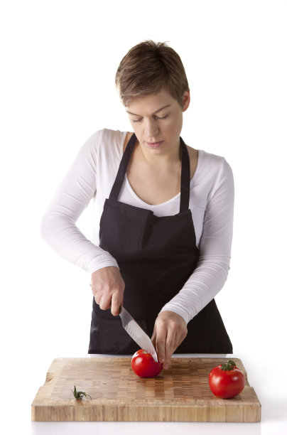 年轻的厨师正在切番茄图片下载