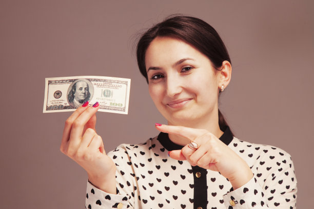 快乐的年轻女子，手指在钱图片下载