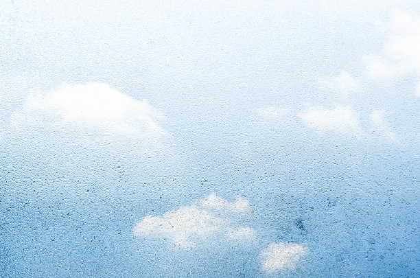 水滴和天空透过玻璃背景。窗户上凝结着水珠。房间湿度大。图片下载