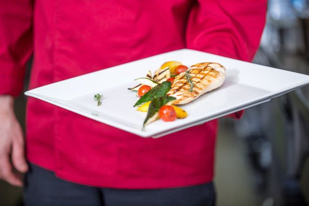 酒店或餐厅厨房厨师准备饭菜，烤鸡胸肉蔬菜白盘图片下载