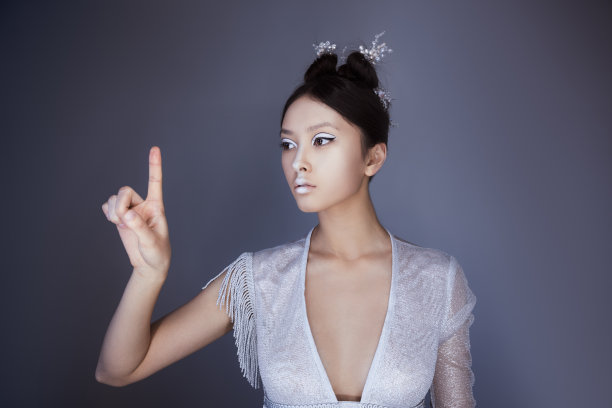 年轻漂亮的亚洲未来女人按一个虚构的按钮，空的空间的按钮图片下载