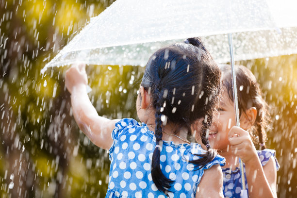 两个快乐的亚洲小女孩带着伞玩雨图片下载