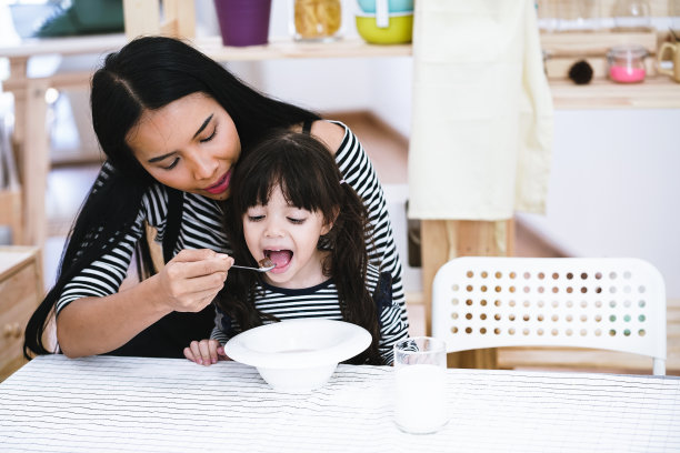 情景:妈妈用牛奶喂麦片粥。图片下载