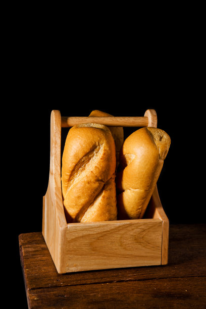 新鲜出炉的法式长棍面包放在桌子的背景上。图片下载