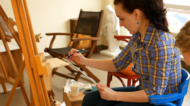 女艺术家在画室里画铅笔画图片下载