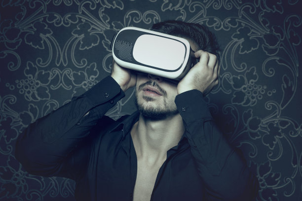 年轻的白种人在虚拟现实头盔享受模拟，在电影风格图片下载