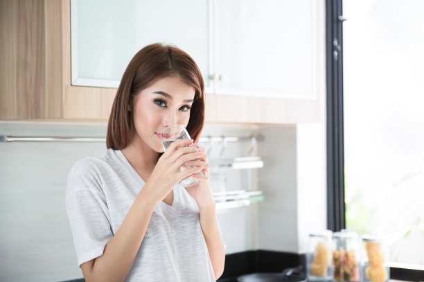 轻松微笑的年轻女子喝干净的水图片下载