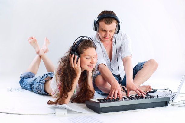 女人和男人正坐着谱曲。孤立的白色背景。在摄影棚里拍的。图片下载