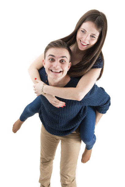 年轻幸福的夫妇一起玩背靠背孤立在白色的背景图片下载