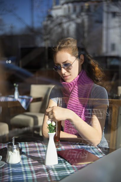 餐馆窗户后面的年轻女子图片下载