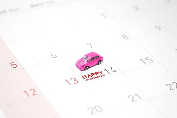 粉红色的玩具车，一个微型公园在2月14日的日历上用短信祝情人节快乐。图片下载