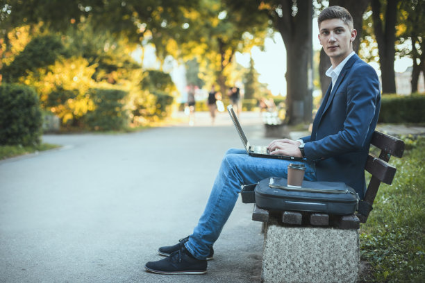 一个商人在公园里用笔记本电脑工作图片下载