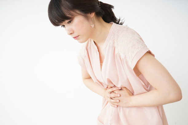 一位年轻女子正遭受胃痛的折磨图片下载