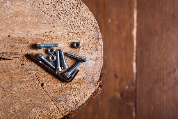 木背景上的六角头螺钉、螺母和六角键图片下载