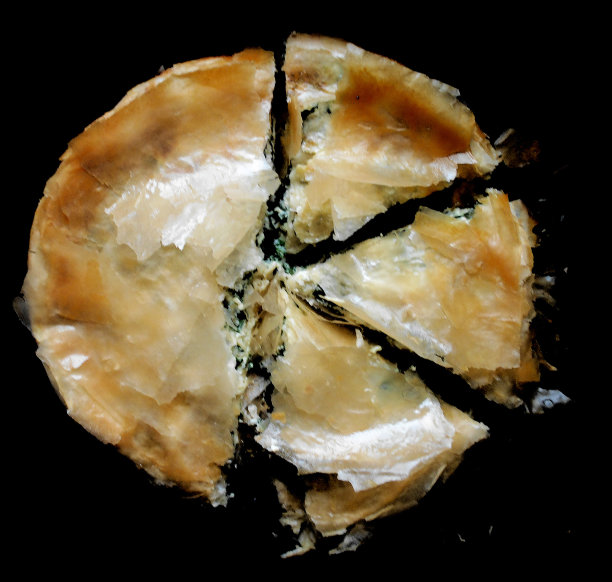 切碎的圆形派与奶酪和绿色，多叶蔬菜，甜菜或菠菜图片下载