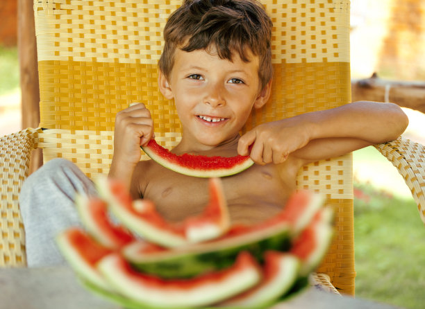 可爱的小男孩拿着西瓜皮微笑着图片下载