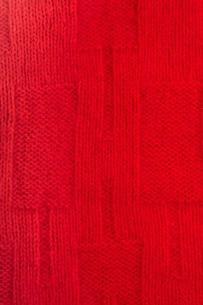 毛衣或围巾面料质地大，针织。针织针织物背景与浮雕图案。编织中的辫子。羊毛手工机，手工，红色图片下载