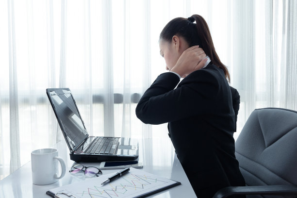 一名压力重重的年轻女性坐在办公桌前的笔记本电脑前的肖像图片下载