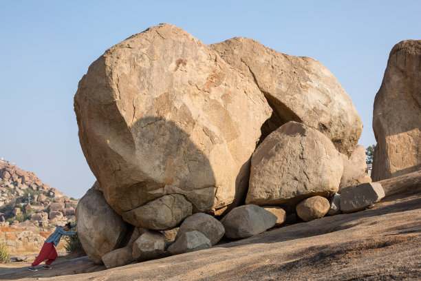一个人独自把一块大石头推入山中图片下载