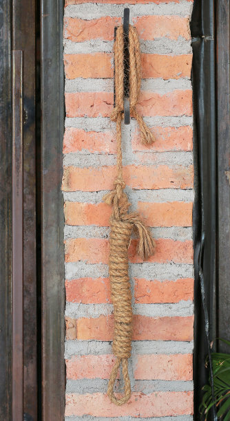 黄绳挂在砖墙上作装饰。图片下载