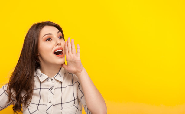 女人在黄色上摆姿势并呼叫素材图片