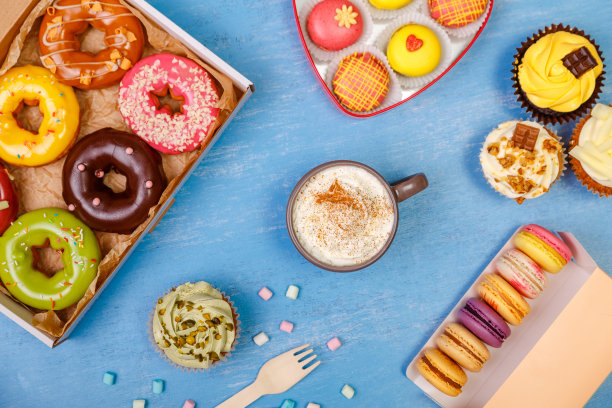 马卡龙、纸杯蛋糕和甜甜圈。杯奶油。图片下载