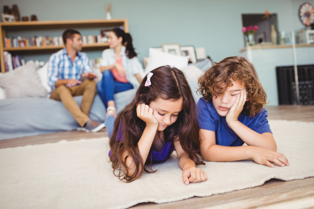 孩子们在地毯上休息，父母在后面图片下载