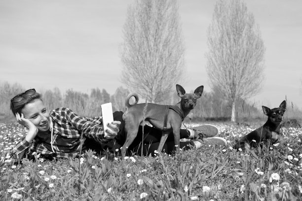 带着两只狗的微笑女孩拍了张自拍图片下载