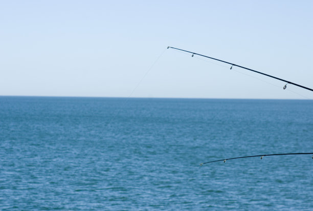 在海洋上延伸的钓竿图片下载