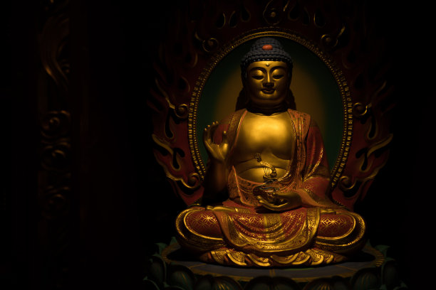 金色佛像雕塑在一个黑暗的背景图片下载