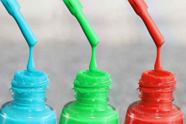 指甲用的漆。女性用丙烯酸漆，指甲用凝胶漆。指甲的紫胶混合色。呵护女人的双手。女人的修指甲。手上指甲用的清漆。图片下载