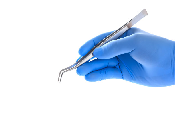 医生的手拿着镊子夹径图片下载